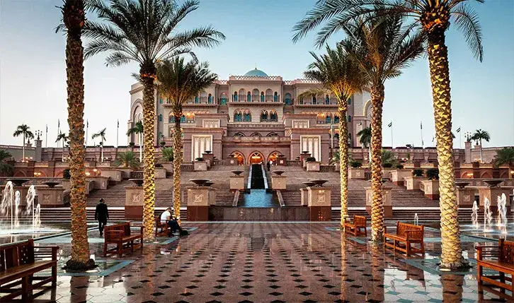 Emirates Palace hotel behind its fountains and palm avenue in Abu Dhabi
