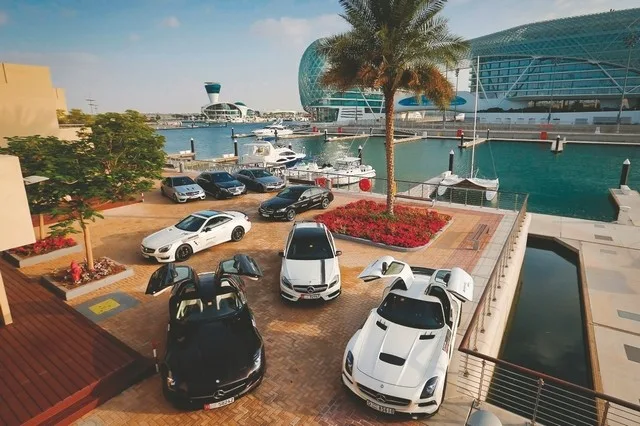 Luxury supercars parked on the Yas Marina waterfront with the Yas Viceroy hotel behind