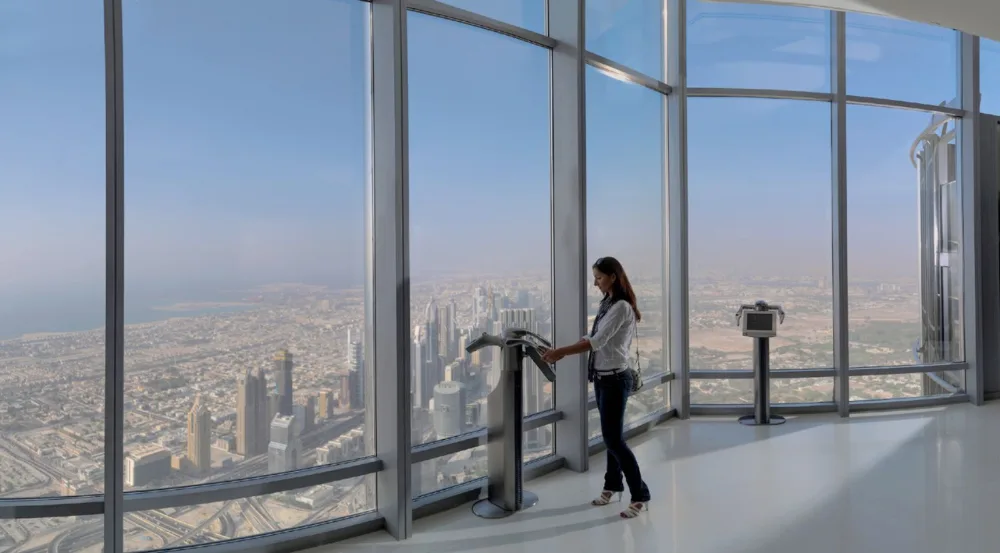 Guest using a telescope at Burj Khalifa At The Top during the day
