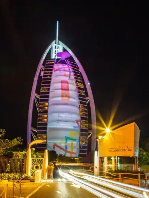 Burj Al Arab illuminated at night, seen from the Welcome Centre gate on a Dubai city tour