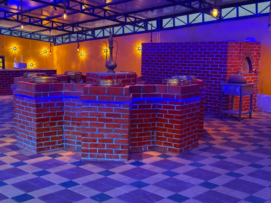 Brick buffet counter with chafing dishes and a bread oven at the VIP desert safari camp